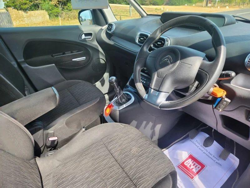 The steering controls of a silver Citroen Picasso viewed from above the driver seat