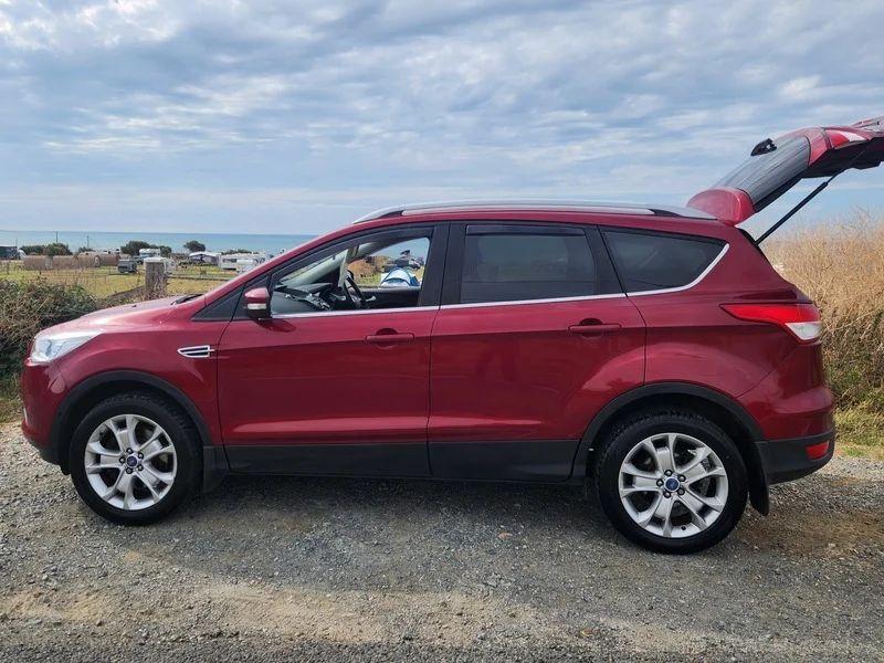A red Ford Kuga viewed from the passenger side