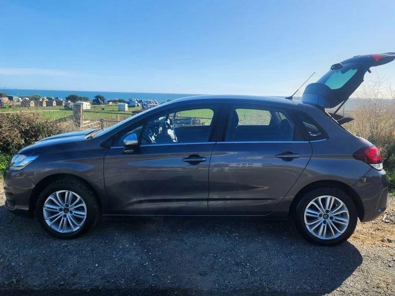 A Shark Grey Metallic Citroen C4 with an open boot viewed from the passenger side