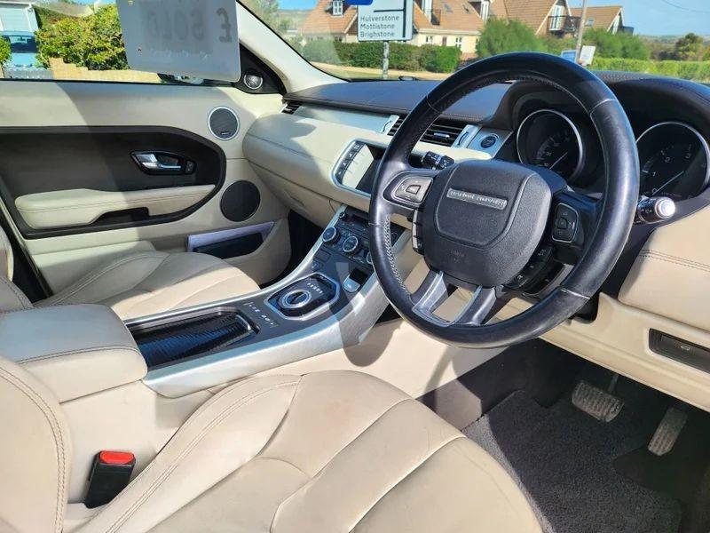 The steering controls of a Santorini Black Range Rover viewed from above the driver seat