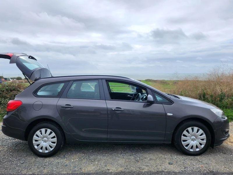A Grey Vauxhall Astra with an open boot viewed from the driver side