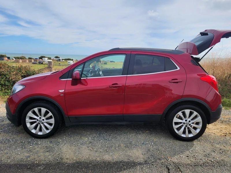 A Velvet Red Metallic Vauxhall Mokka with an open boot viewed from the passenger side