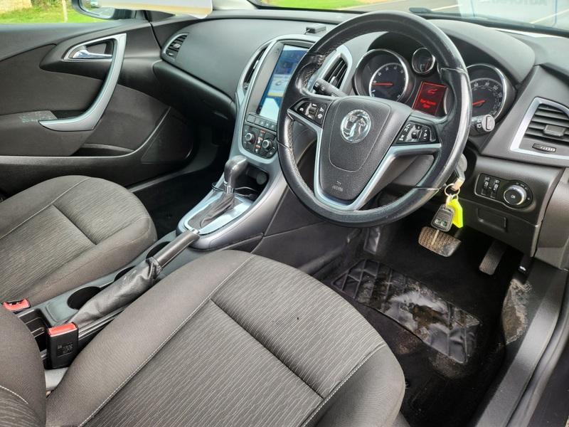 The steering controls of a Grey Vauxhall Astra viewed from above the driver seat