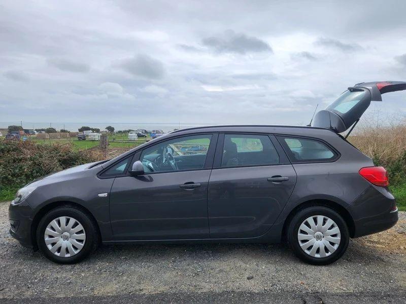 A Grey Vauxhall Astra with an open boot viewed from the passenger side