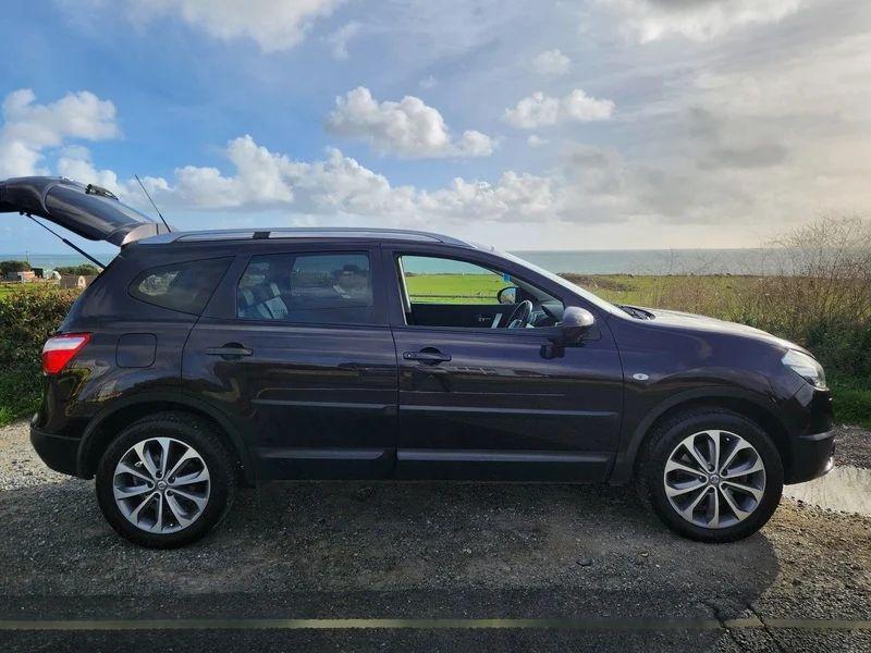 A Nightshade Black Metallic Nissan Qashqai viewed from the driver side